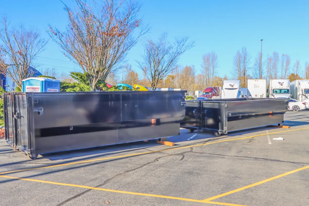 Professional dumpster rental service with roll-off container on residential driveway in Four Corners